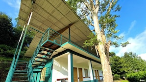 A two-story building with a staircase and a covered porch. - Whispering Willows (Mudumalai)