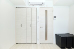 Una habitación con armario, aire acondicionado y una mesa negra.