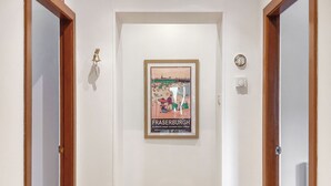 A hallway with a framed poster on the wall, a doorbell, and a light switch. - 3 bedroom accommodation in Fraserburgh (Fraserburgh)