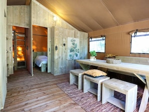 A rustic cabin interior with a wooden floor, a bed, a bench, a table, and a window. - Holiday Home in Otterlo With Terrace (Otterlo)