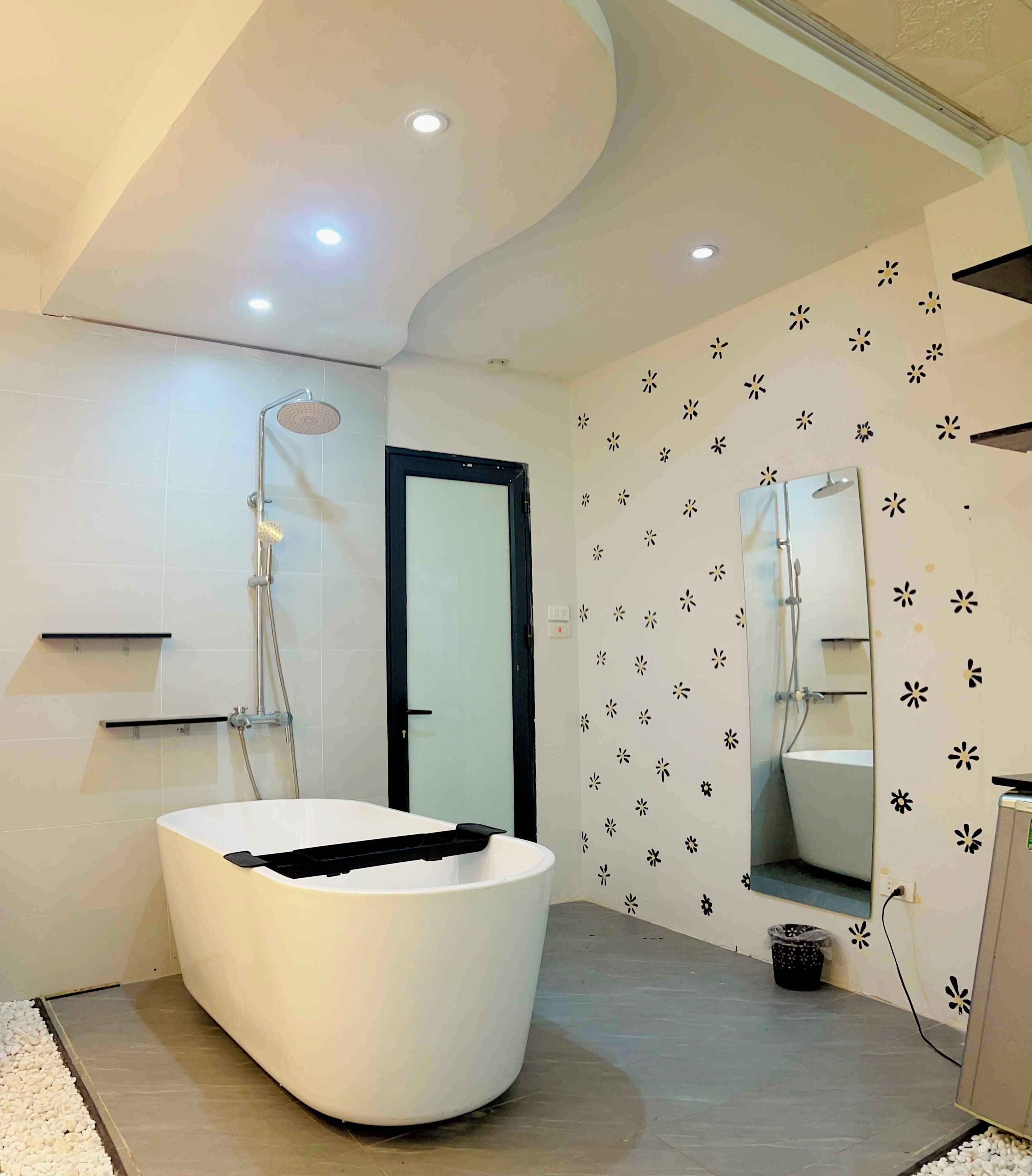 Een moderne badkamer met een vrijstaand bad, een douche en een spiegel.