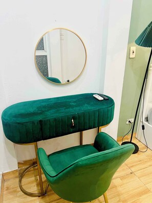A green vanity with a round mirror, a chair, and a lamp. - LushStay Central Train Station (Cua Nam)