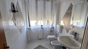 Un bany modern amb vàter, bidet, rentapel i zona de dutxa.