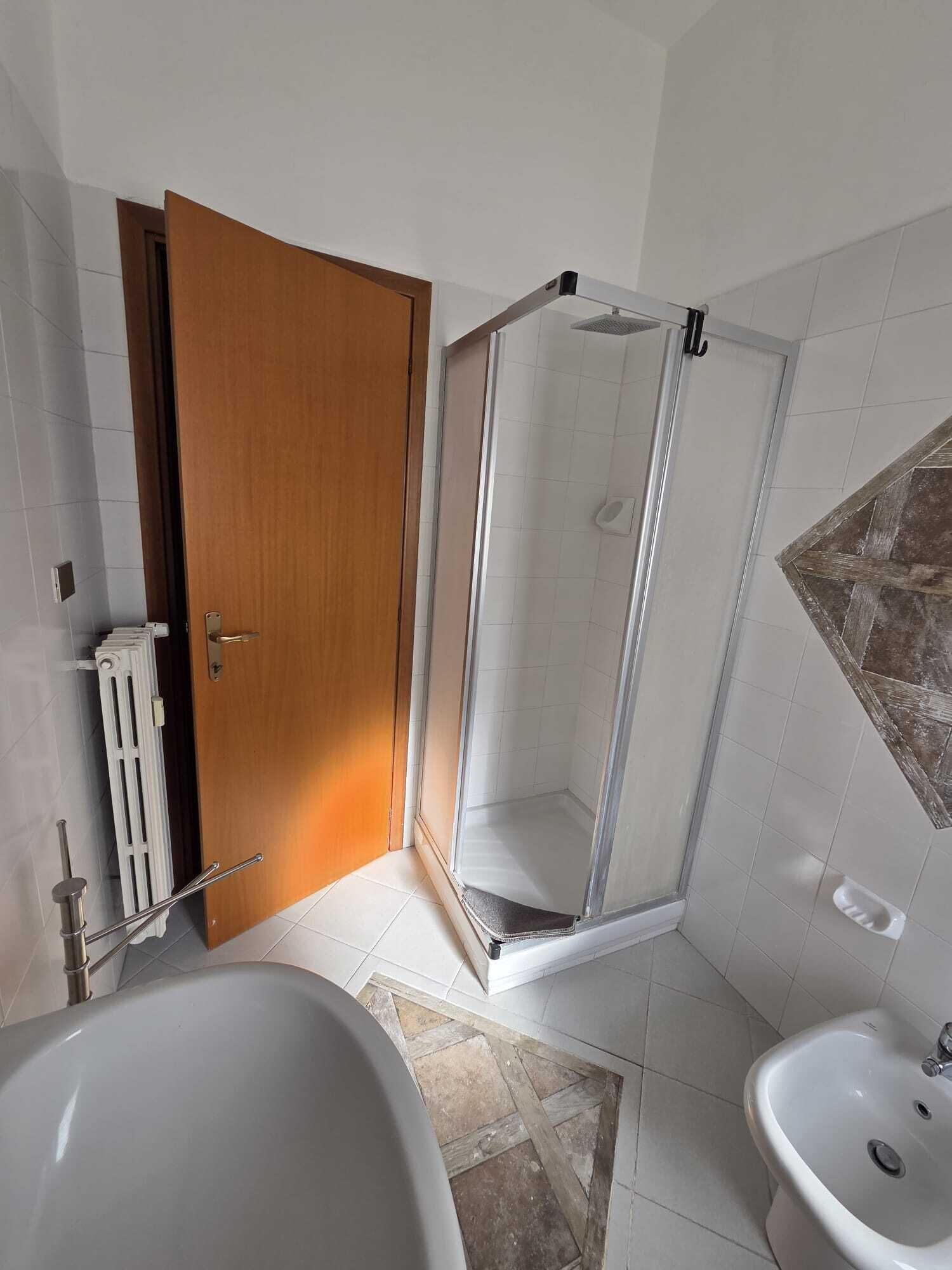 Une salle de bain avec une douche, des toilettes et une baignoire.