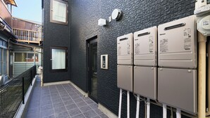 A building with a black brick exterior, a door, and a small window.