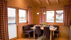 Un intérieur en bois comprenant une table à manger, des chaises et un banc.