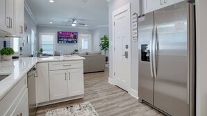 Una cocina moderna con armarios blancos, un refrigerador de acero inoxidable y una isla central.