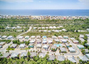 Eine Küstenwohngegend mit zahlreichen Häusern, einer zentralen Straße und Blick auf den Ozean.