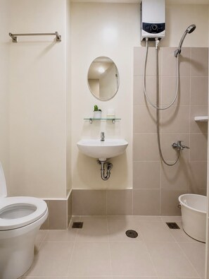 A modern bathroom with a toilet, sink, mirror, shower, and a towel rack. - Cabina Baguio | Cozy Studio Near Session Road w/ Gym & Sauna (Baguio)