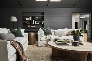 Ein modernes Wohnzimmer mit einer Couch, einem Couchtisch und einem Bücherregal.