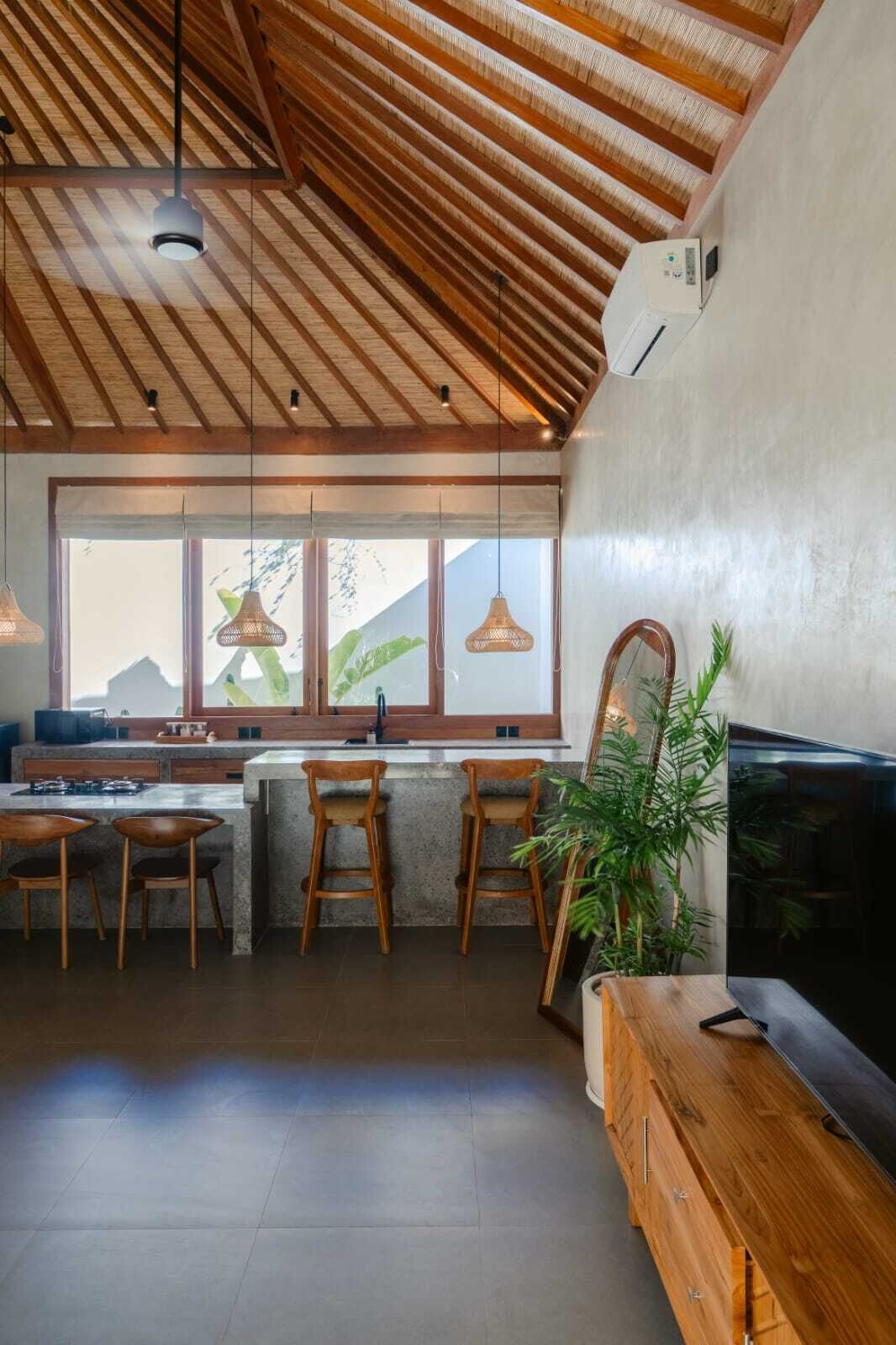 Una cocina moderna con un ventanal grande, techo de madera y taburetes de bar.