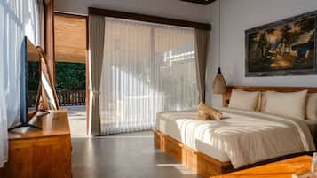 Un dormitorio con una cama grande, una mesita de noche de madera, un cuadro en la pared y un ventanal corredero que da a un espacio exterior.