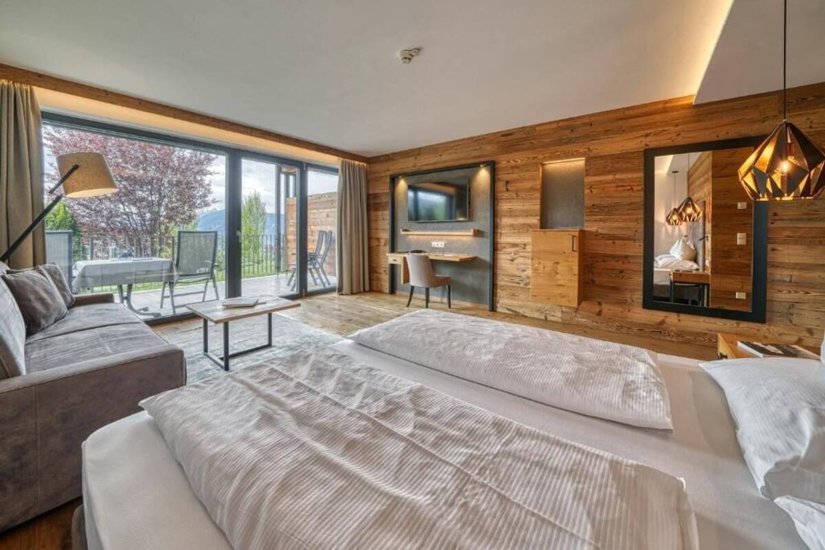 Une chambre d’hôtel moderne équipée d’un grand lit, d’un canapé, d’un bureau et d’une télévision.