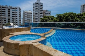 Ein Dachpool mit Schachbrettmuster, umgeben von Hochhäusern und Grünflächen.