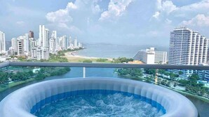 Ein Whirlpool mit Blick auf die Stadt, inklusive Wolkenkratzern und einem Strand.