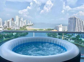 Ein Whirlpool mit Blick auf die Stadt, inklusive Wolkenkratzern und einem Strand.