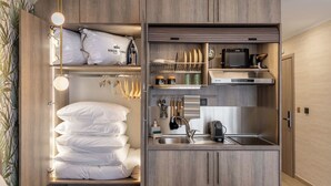 A compact kitchen with built-in appliances, a sink, and storage cabinets.