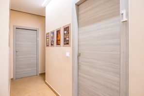 A hallway with two closed doors, one marked with the number 3, and a wall with four framed pictures. - MDC Luxury Rooms Naples (Naples)