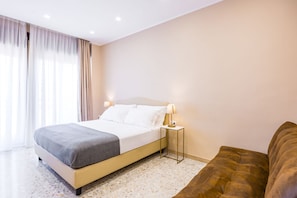 A hotel room with a bed, bedside lamp, and a view of the outdoors. - MDC Luxury Rooms Naples (Naples)