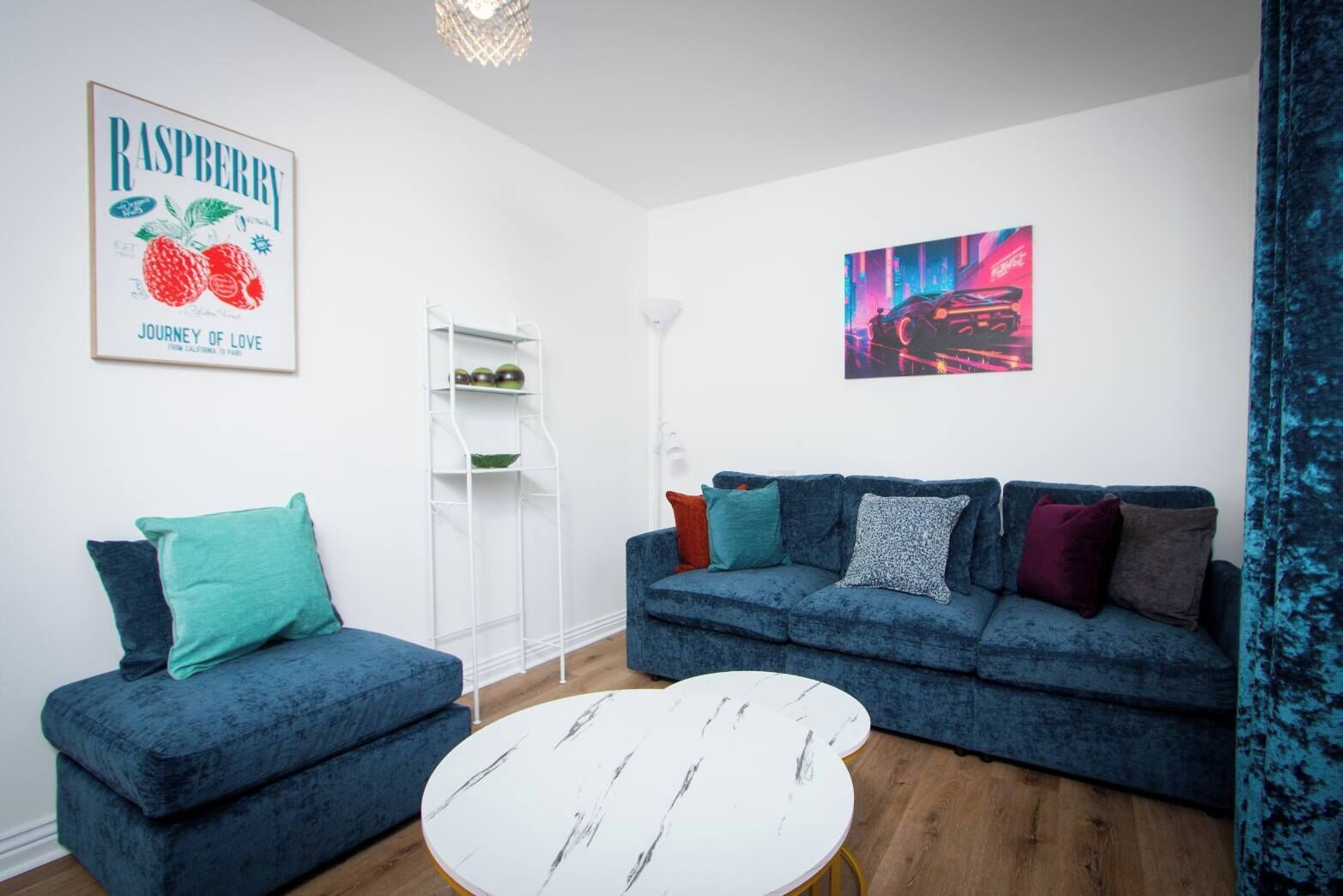 A living room with a blue sofa, a white coffee table, and a bookshelf.