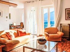 Ein Wohnzimmer mit Sofa, Sessel und Glastisch.