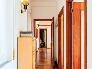 Ein Flur mit Holzboden, einem Holzschrank und einer Tür mit Messinggriffen.