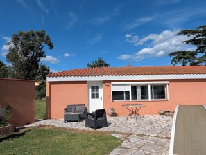 A house with a patio, a white door, and a window.