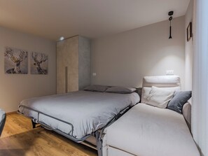 A bedroom with a bed, a wardrobe, and two wall-mounted paintings. - La Spada by Interhome (Pellizzano)