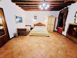 Una camera da letto con un letto, un armadio, un lampadario e un quadro appeso al muro.