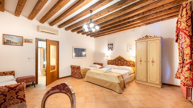 Una camera da letto con un letto, un armadio, una sedia e una porta che dà su un'altra stanza.