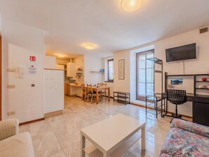Um apartamento moderno com área de refeições, cozinha e sala de estar.