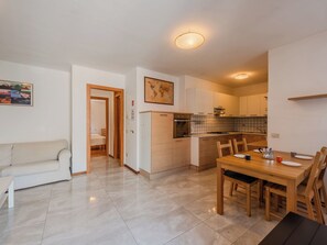 Een modern appartement met een eethoek, keuken en een woonkamer met een bank.