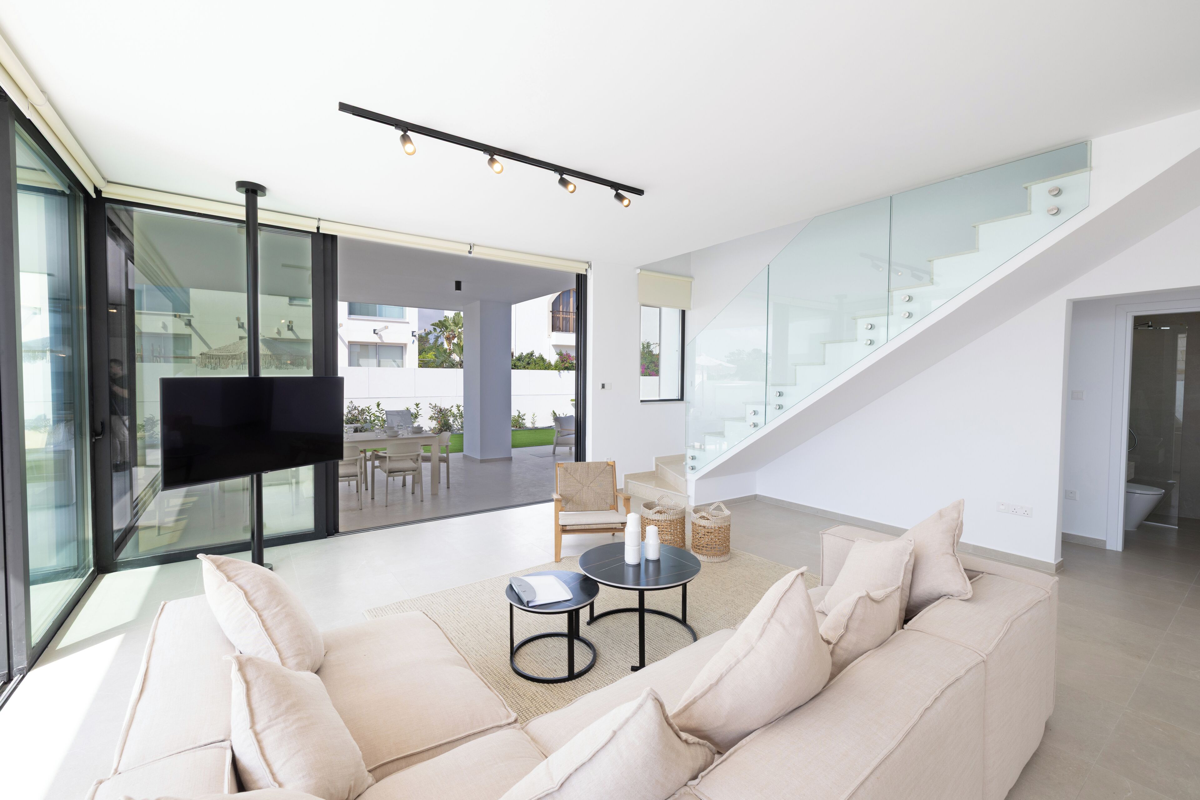 A modern living room with a sofa, coffee table, and a flat-screen TV.
