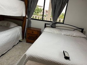 Une chambre avec deux lits, une table de chevet et une fenêtre avec des rideaux.