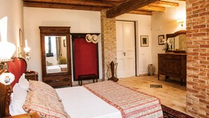 Ein Schlafzimmer mit einem Bett, einem Schminktisch, einem Spiegel, einer Tür und einer Ziegelwand.