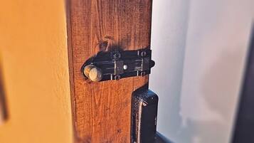 Une porte en bois avec un loquet métallique et une poignée de porte ronde.