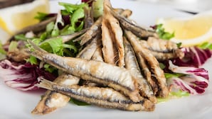 A plate of fried fish with salad and lemon wedges. - 'Picchio' Room with Wi-Fi and Air Conditioning (Taglio di Po)