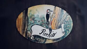 Ein ovales Objekt mit einer Vogelillustration und dem Wort 'Picchio'.