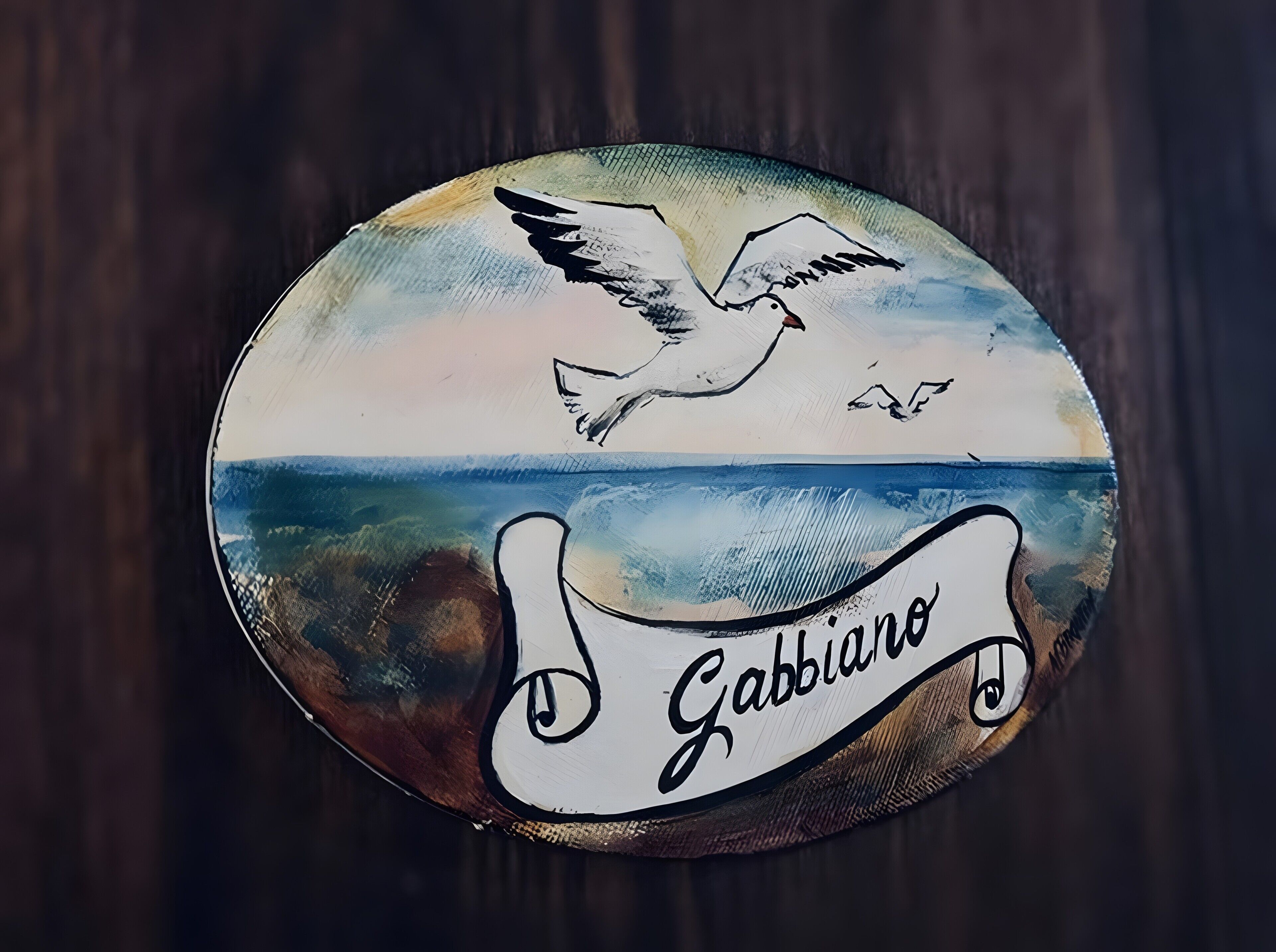 Un letrero circular con un ave y olas, y el texto 'Gabbiano'.