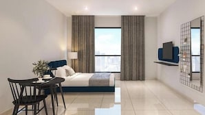 A modern hotel room with a bed, a dining table with chairs, a TV, and a city view. - Portrait Resort Port Dickson (Port Dickson)