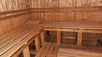 Eine Sauna mit Holzbänken und schräg versiegelter Decke.