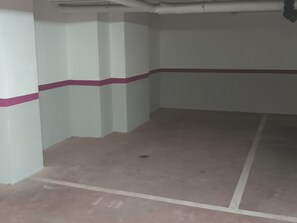 Une pièce aux murs blancs, ornée d’une bande rose, et dont le sol est recouvert de carreaux, avec le chiffre « 19 » qui y est peint.