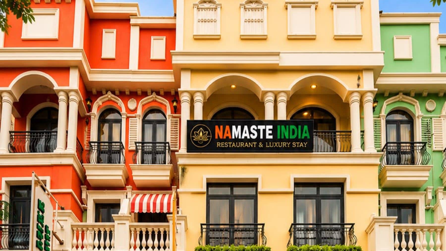 Une rangée de bâtiments colorés, dotés de balcons, et une enseigne indiquant « Namaste India Restaurant & Luxury Stay ».