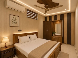 Ein Schlafzimmer mit Bett, Nachttisch, Wand-Klimaanlage, Deckenventilator und großem Kleiderschrank.