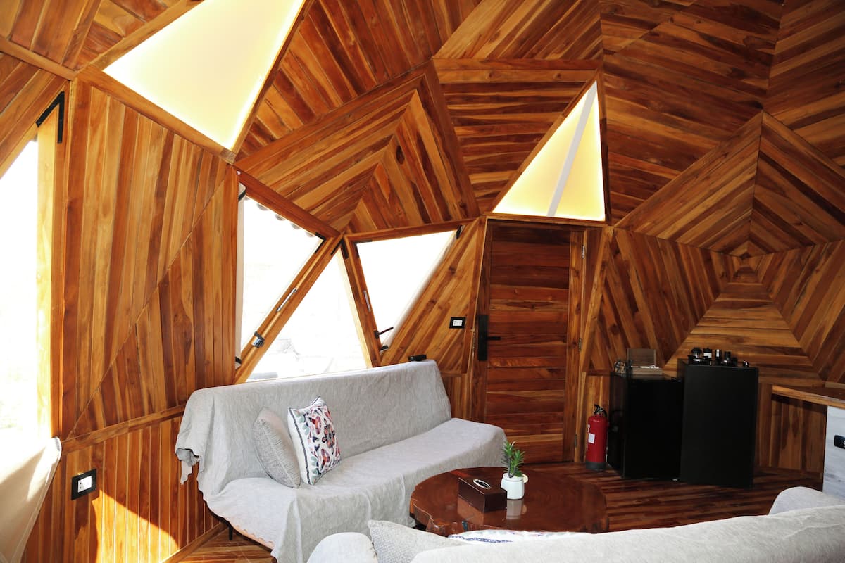 Un interior de madera con un sofá, una mesita y una chimenea.