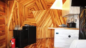 A wooden interior with a kitchen area, a white cabinet, and a fire extinguisher. - Sama Tannourine Dome Houses (Tannourine El Faouqa)