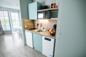 A modern kitchen with a dishwasher, a microwave, and a sink. - Relaxing Wellness Getaway in Bagnoles (Bagnoles de l'Orne Normandie)