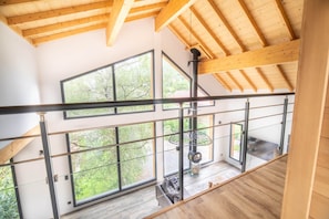 A modern interior with a wooden ceiling, large windows, and a spiral staircase. - Chalet Lignum, Sauna & SPA, Near Ski Slopes (La Bresse)