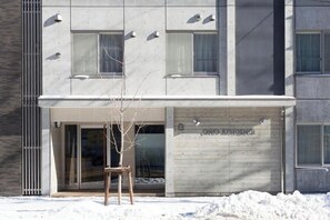 A modern building with a covered entrance, a sign reading 'ONE'S RESIDENCE,' and a snow-covered ground. - ONESATwin Room / Sapporo Hokkaidō (Sapporo)