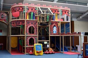 A play structure with multiple levels and slides, enclosed by a safety net. - Holiday home in Dornum with swimming pool (Dornum)